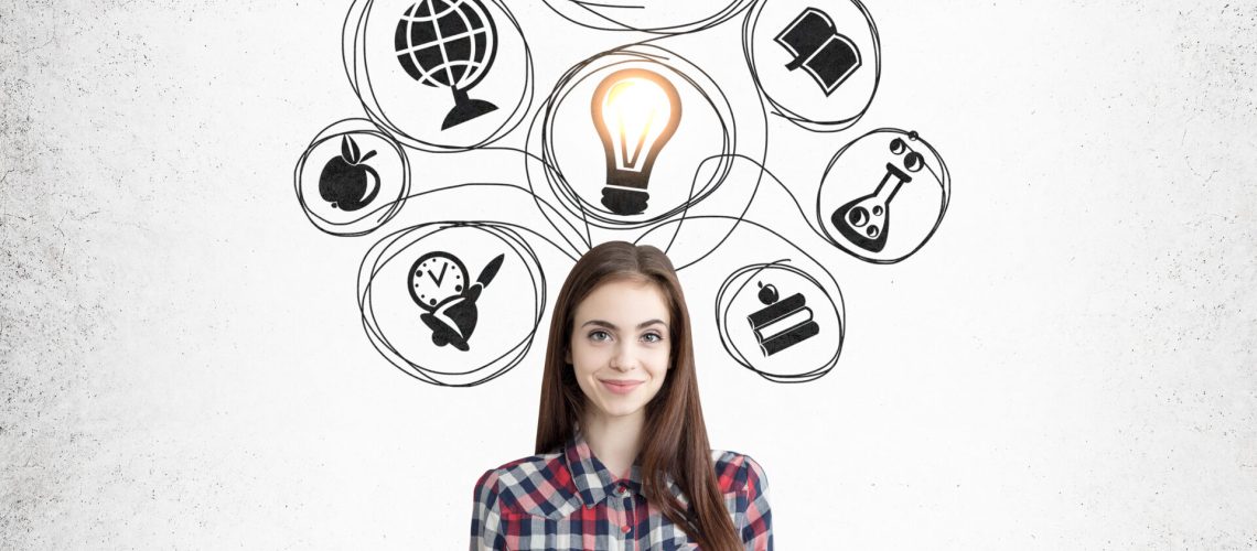 Smiling nerdy girl with a book is standing near concrete wall with black education icons. Concept of importance of knowledge